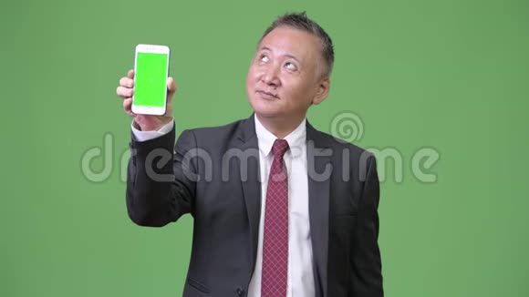 成熟的日本商人展示手机摄像头视频的预览图