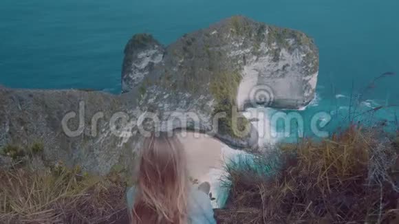 坐在悬崖上欣赏美丽景色的女孩视频的预览图