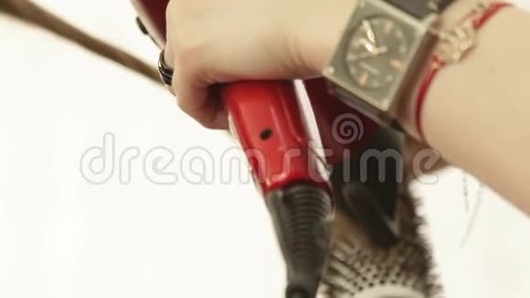 理发师使用吹风机和梳子在美容工作室理发后烘干和定型长发关门视频的预览图