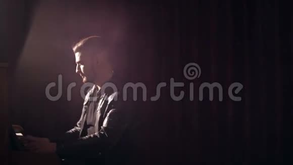 音乐家在黑暗的工作室里弹钢琴镜头闪耀视频的预览图