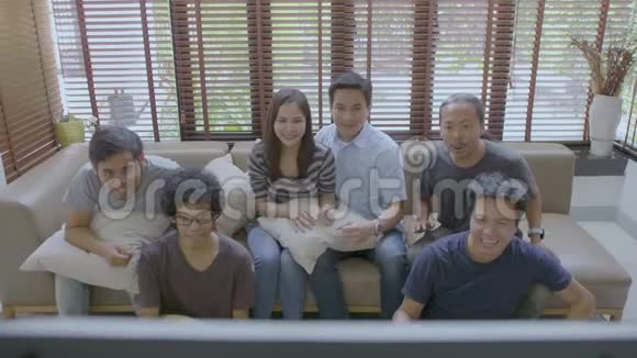 一群亚洲室友在家里看体育比赛视频的预览图