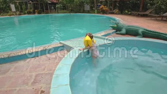 酒店的小女孩用雨伞从游泳池里蹦出来视频的预览图
