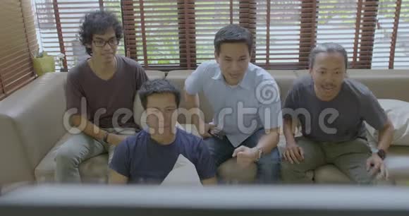 一群亚洲室友在家里看体育比赛视频的预览图