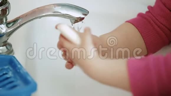 孩子女孩或男孩用肥皂在白色水槽里洗手视频的预览图