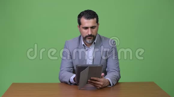英俊的波斯胡子商人在使用数码平板电脑时思考视频的预览图