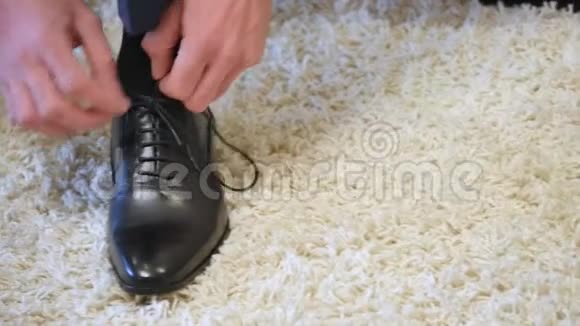 在拜访新娘之前在家里用黑色鞋子系鞋带男人在结婚前准备时髦的衣服视频的预览图
