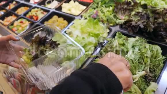 购物中心沙拉酒吧年轻女性为沙拉购买有机蔬菜素食者带走食物健康饮食视频的预览图
