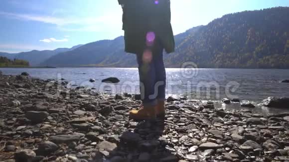 阿尔泰两个视频合一露营妇女坐在山湖畔穿着登山靴的女孩的脚视频的预览图