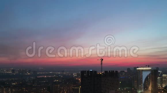 一只起重机在日落的背景下在城市工作视频的预览图