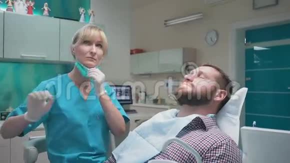牙医检查病人牙齿解释他的程序斯坦迪卡姆视频的预览图