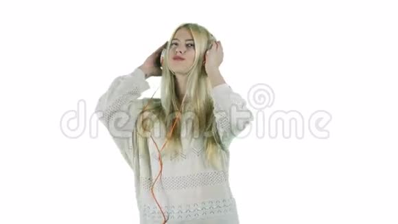 带着耳机听音乐的年轻女子微笑着用白色背景上的摄像机调情视频的预览图