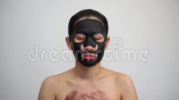 年轻女子做带净化面膜的黑色面膜视频的预览图