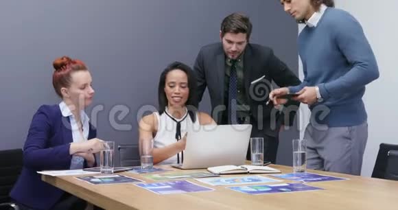 一组高管在办公桌4k上讨论笔记本电脑视频的预览图