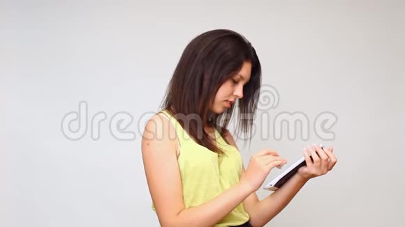 一个女孩看着平板电脑正在探索互联网视频的预览图