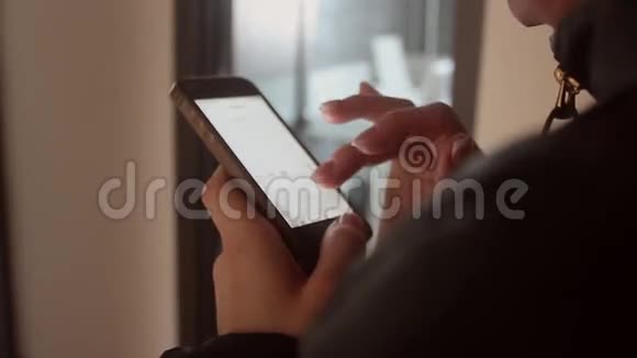女人用她的手机闭上双手室内室视频的预览图
