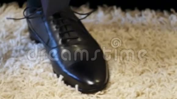 在拜访新娘之前在家里用黑色鞋子系鞋带男人在结婚前准备时髦的衣服视频的预览图
