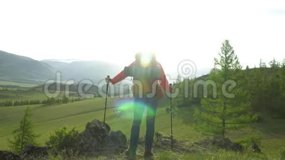 那个背着红色背包的女人悲伤地走上前去雪山景色早晨的太阳手里拿着棍子的女人视频的预览图