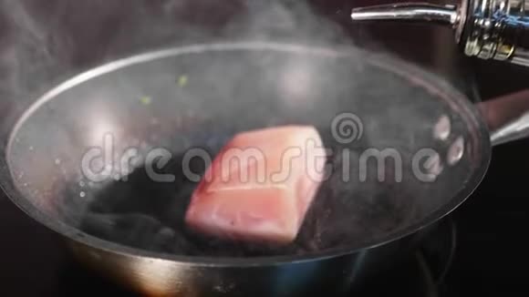 锅炸鱼吞拿鱼片在热气腾腾的煎锅上慢动作视频的预览图