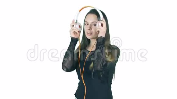 年轻的微笑的女人戴上耳机开始听白色背景下孤立的音乐视频的预览图