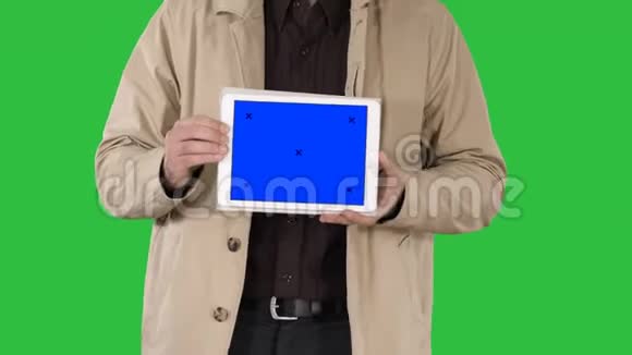 男性手拿平板电脑与蓝色屏幕模拟在绿色屏幕色度键视频的预览图