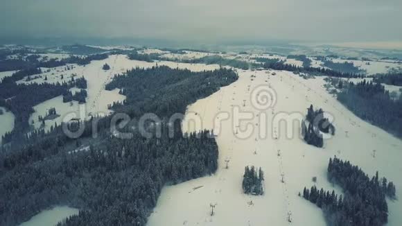 冬季雪覆盖高山滑雪斜坡的空中景观波兰南部的滑雪胜地塔特拉山视频的预览图