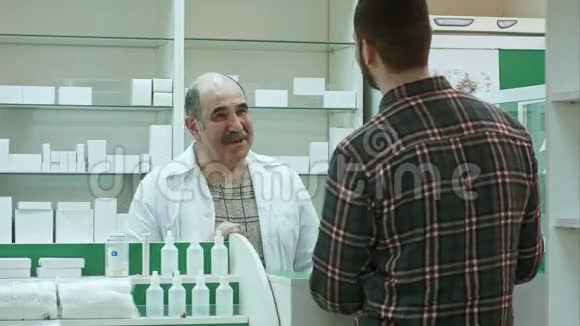 积极的高级药剂师在药房给客户吃药视频的预览图
