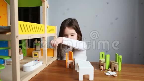一个可爱的女孩在玩玩偶屋视频的预览图
