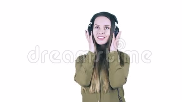 一位梦幻般的年轻女子戴着耳机听音乐微笑着对着镜头亲吻视频的预览图