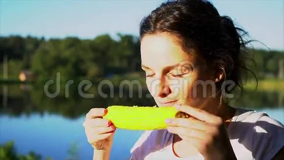 美丽的女孩在吃煮玉米视频的预览图