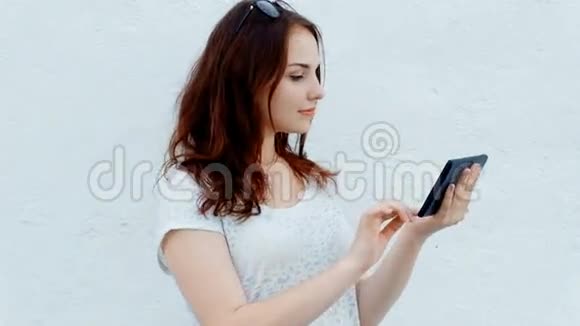 可爱的女人在户外公园放松时使用她的平板电脑视频的预览图