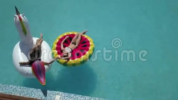 穿比基尼的年轻女朋友在游泳池里享受夏日阳光和假日晒黑视频的预览图