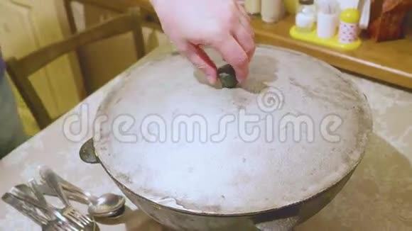 男性厨师的手用煮熟的蔬菜从大锅上取下盖子视频的预览图