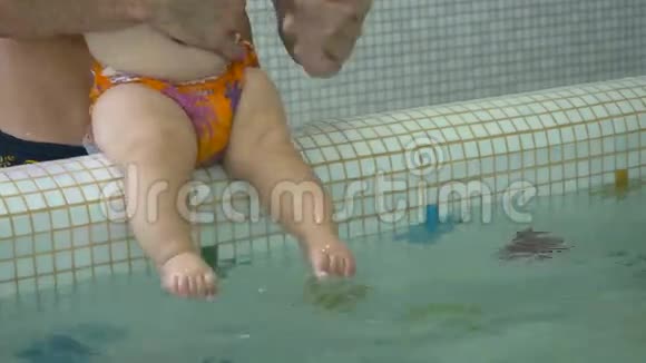 小男孩坐在儿童游泳池的一侧吮吸手指视频的预览图