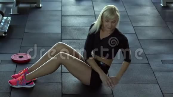 年轻女子在健身房里摇着地板上的压力视频的预览图