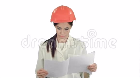 戴安全帽的年轻工程师女士在白色背景下检查技术图纸视频的预览图