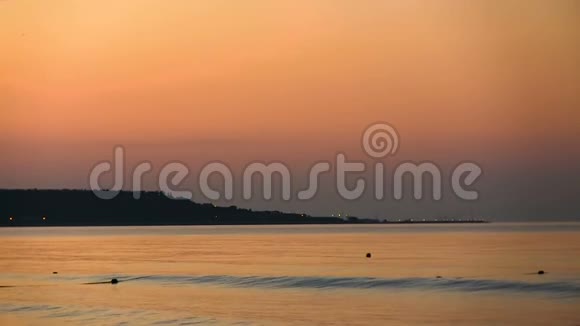海岸线在橙色黎明的背景下海上平静视频的预览图