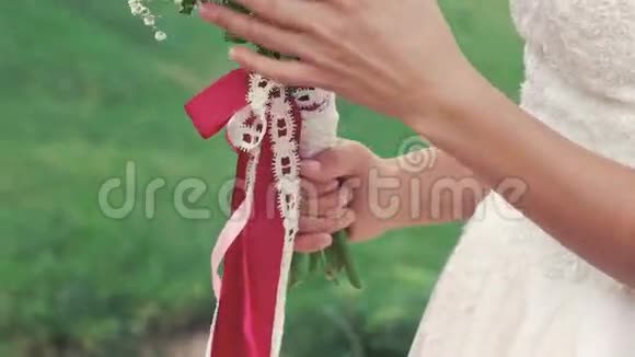 靠近新娘嗅着花束在田野里微笑慢慢地视频的预览图