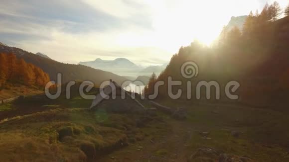 在秋天的小路上行走在日落时登上住宿山谷湖和雪上坐骑太阳耀斑晴朗的秋日视频的预览图