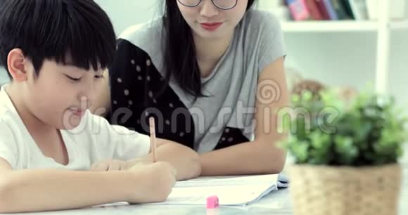 亚洲妈妈正在帮她儿子做家庭作业视频的预览图