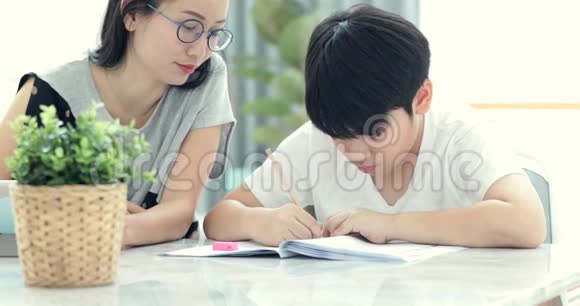 亚洲妈妈正在帮她儿子做家庭作业视频的预览图