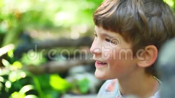 大自然中微笑的小男孩的肖像视频的预览图