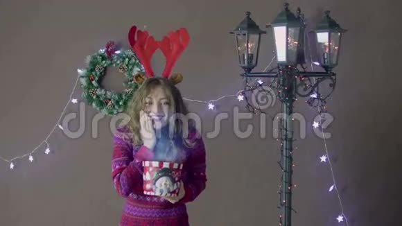 美丽的圣诞老人助手圣诞女孩拿着糖果罐在圣诞装饰的背景下闪耀着光芒视频的预览图