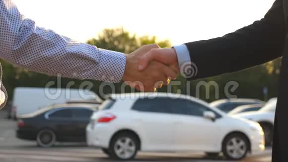 穿西装的男性把车钥匙给他的朋友商人的手臂通过汽车钥匙两个企业之间的握手视频的预览图