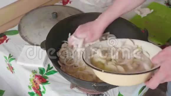 白色厨师的手加入切黄洋葱并将红胡椒倒入肉片同时烹饪圆顶视频的预览图