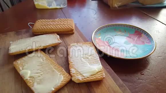 用刀子把黄油撒在麦饼干上吃早餐视频的预览图
