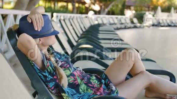 戴着夏帽的年轻美女在泳池边休息视频的预览图