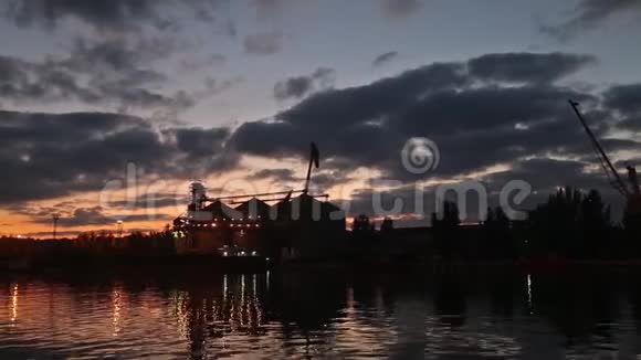 傍晚海港大粮码头全景谷物在夜间散装转运到船上装载谷物视频的预览图
