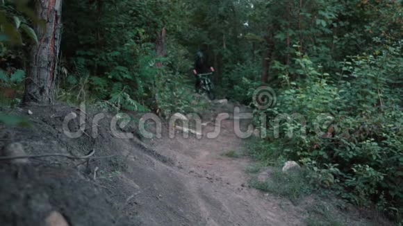 山地自行车手在森林中沿着公路行驶动作缓慢视频的预览图