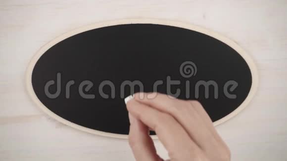一个女人的手在黑板上用白垩画一颗手工的心视频的预览图