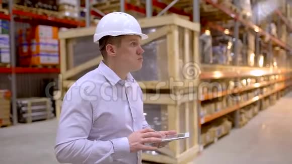 员工男仓库工人工程师戴安全帽在施工现场仓库工作在物流中行走视频的预览图